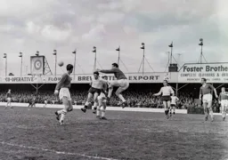 Charlton goalkeeper Frank Reed punches the ball off the head of Gordon Turner