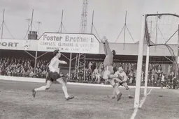 Mansfield keeper Colin Treharne saves from the onrushing Tommy McKechnie