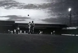 As the sun sets over Kenilworth Road Gordon Riddick heads the ball towards the darkening sky