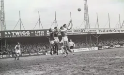 Malcolm Macdonald ries to the ball