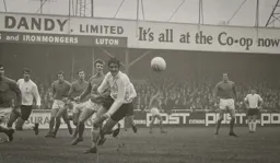 Don Givens watches the ball fly past