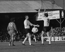 Goal provider Don Givens is congratulated by his skipper Mike Keen
