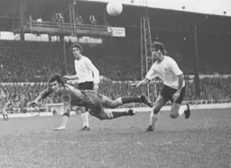 A spectacular clearing header thwarts Don Givens and Viv Busby