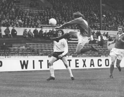 Don Givens sees the ball cleared by the Swindon defence