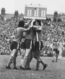 John Aston is mobbed by his team mates
