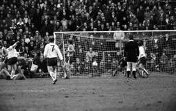 Town defence watches as the ball heads for goal