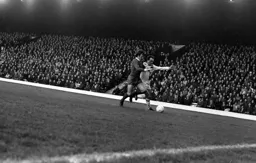 Hard man Tommy Smith challenges John Aston