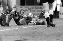 Jimmy Husband hold his knee and looks in pain