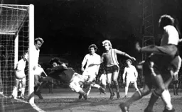 Oxford goalkeeper Roy Burton pushes another Luton strike around a post