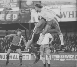 Ron Futcher is beaten to the ball watched by Alan West