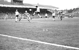 Paul Futcher tries to make a challenge watched by Ricky Hill
