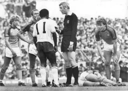 The referee looks none to pleased with Garth Crooks, while Mal Donaghy is concerned about an injured team mate