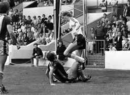 Ashley Grimes steps over Mick Mills