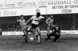 Mick Harford tries to squeeze the ball under the keeper