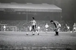 Mark Stein looks for support as Paul McGrath awaits his next move