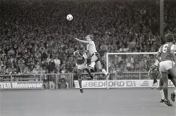 Peter Nicholas soars above Paul Davis to head the ball forward