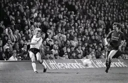 Tim Breacker sends the ball into the penalty area before Ronnie Whelan can react