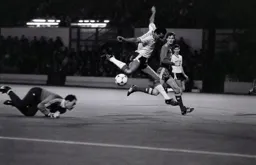 The ball runs loose as Brian Stein hurdles over Bruce Grobbelaar