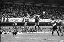 Mick Harford leaps but Peter Jackson heads the ball clear