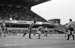 Robert Wilson heads the ball forward as Mick Harford looks on