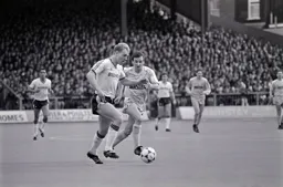 Tim Breacker goes on a characteristic run with future Hatter Paul Allen in pursuit