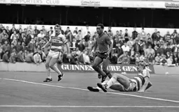 Brian Stein watches as Alan McDonald puts the ball out of play