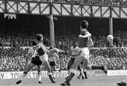 Ricky Hill watches as Kevin Ratcliffe hacks the ball clear