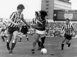 Ricky Hill moves the ball away from Glenn Roeder