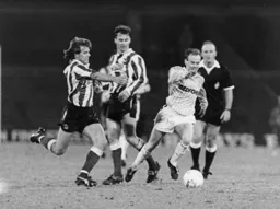 Despite being outnumbered Richard Cooke comes away with the ball