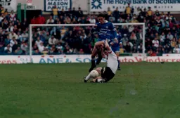 Paul Telfer hurdles a Derby defender