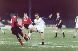 Paul Allen challenges for the ball
