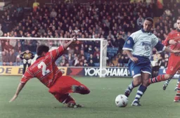 Birmingham's Scott Hiley clears the ball away from the onrushing Scott Oakes