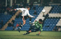 Liam George knocks the ball past Mark Tyler
