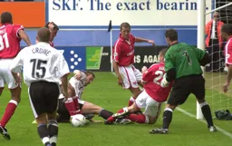 Steve Howard being tackled with Dean Crowe watching on