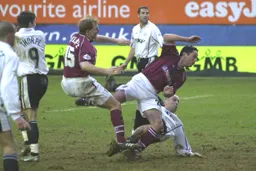 Paul Hughes challenging two Northampton players