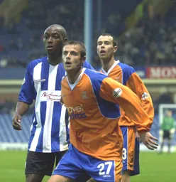 Peter Holmes and Ian Hillier search for the ball as does future Hatter Lloyd Owusu