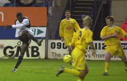 Three Stockport defenders cannot prevent Enoch Showunmi from having a pop at goal