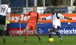 Enoch Showunmi is about to score the only goal of the game before Alan White can intervene