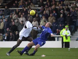 Enoch Showunmi has his eyes on the ball as Guy Branston goes to ground