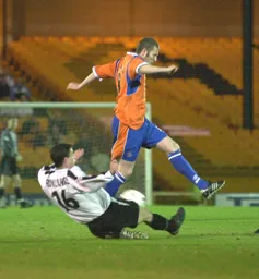 Kevin Nicholls rides a tackle by Steve Rowland