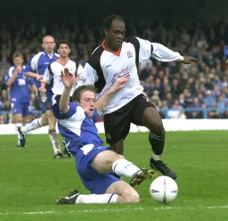 A lunging tackle halts Adrian Forbes