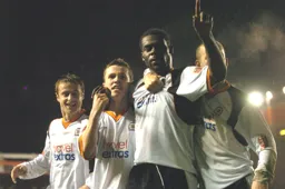 Enoch Showunmi salutes the Luton supporters behind the goal