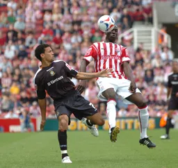 Carlos Edwards and a Stoke player compete for the ball