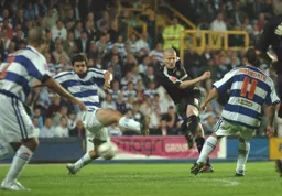 Kevin Nicholls shoots as three QPR players watch on
