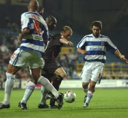 Warren Feeney with the ball surrounded by three QPR players