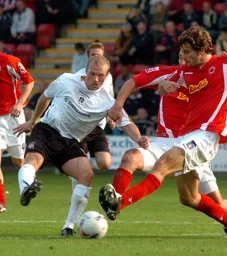 Warren Feeney tries to control the ball from two Crewe players