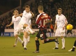 Steven Howard blasts the ball towards the goal watched by Marcus Heikkinen and Peter Holmes
