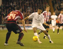 Carlos Edwards prepares to take on a Sheffield United player