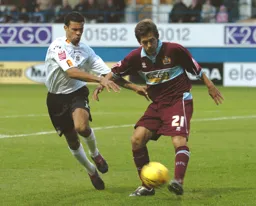 Carlos Edwards goes in for a challenge as the Burnley player strikes the ball