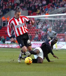Enoch Showunmi slide tackles a Southampton player for the ball